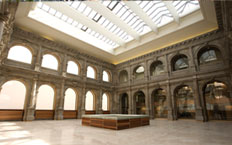 Vue intérieure d'une salle de l'extension du musée du Prado, montrant le toit vitré et la salle avec les portiques